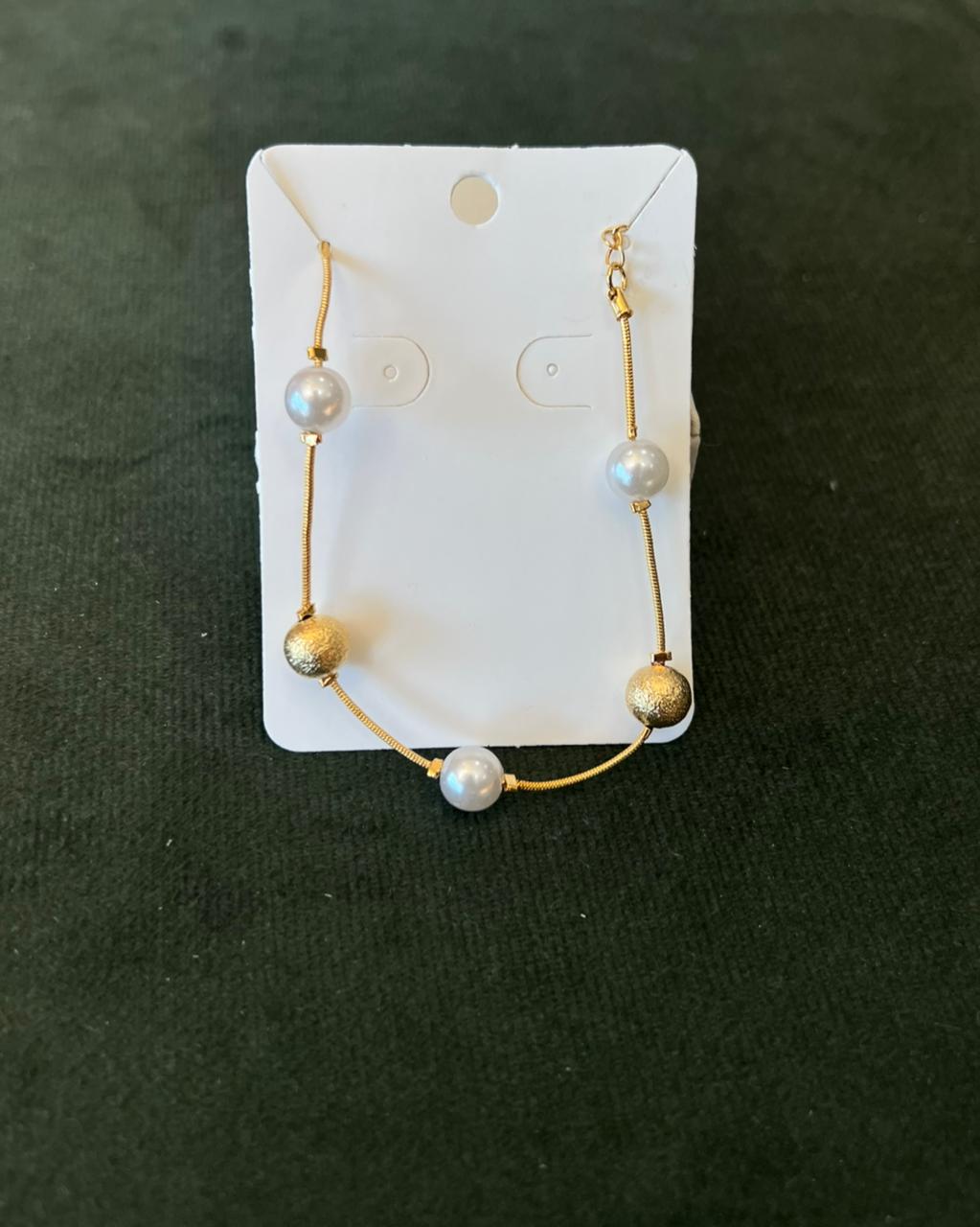 Pulseira de perola com bolinha dourada